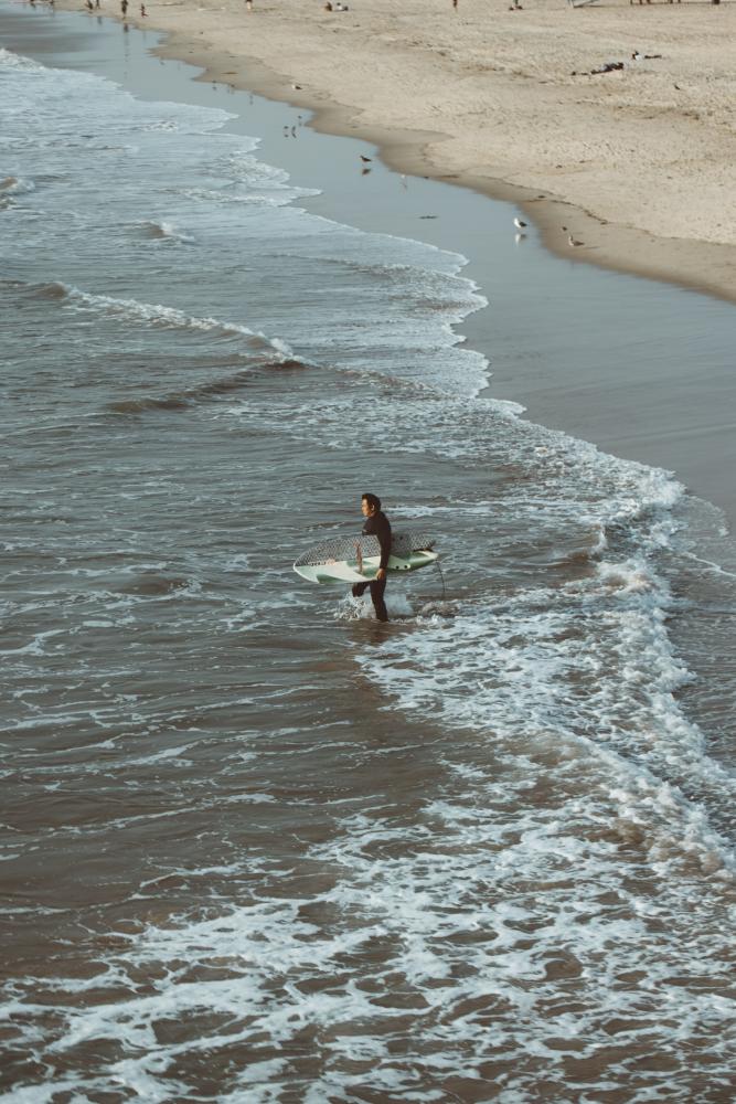 Surfista a entrar na água sozinho