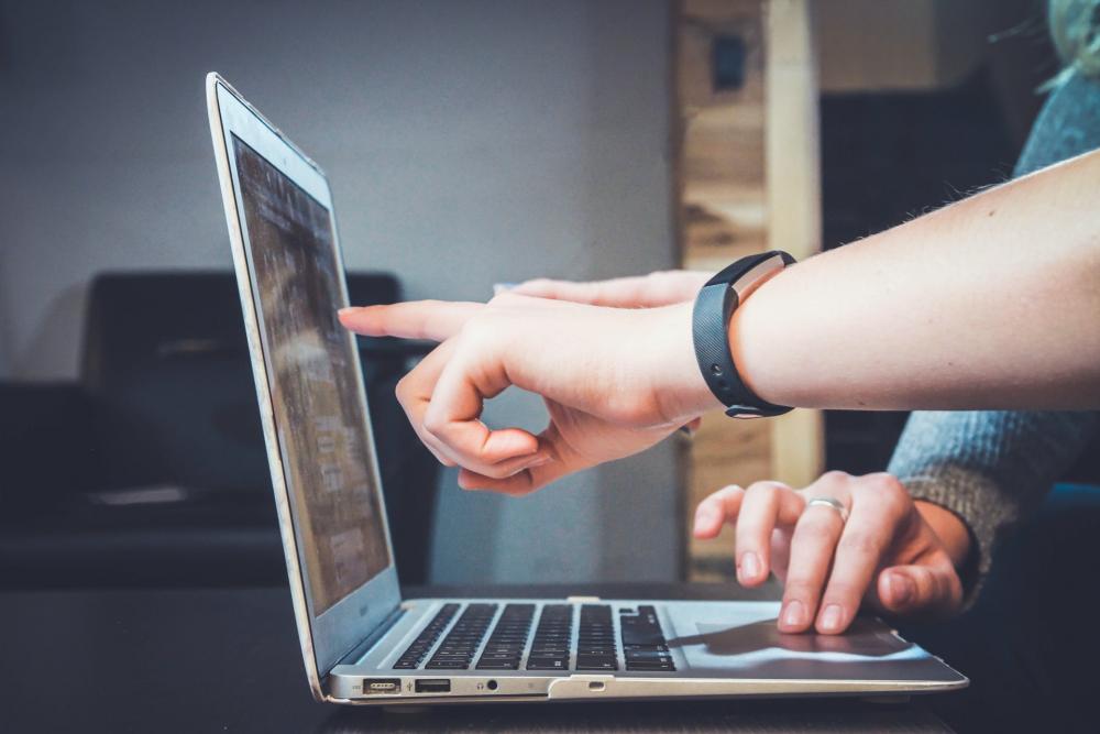 Pessoas a analisar processos num computador