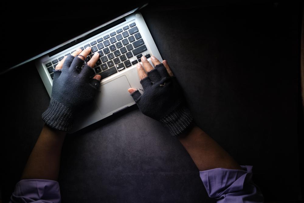 pirata informático com luvas num computador