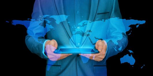 homem a segurar um tablet com o mapa mundo no fundo